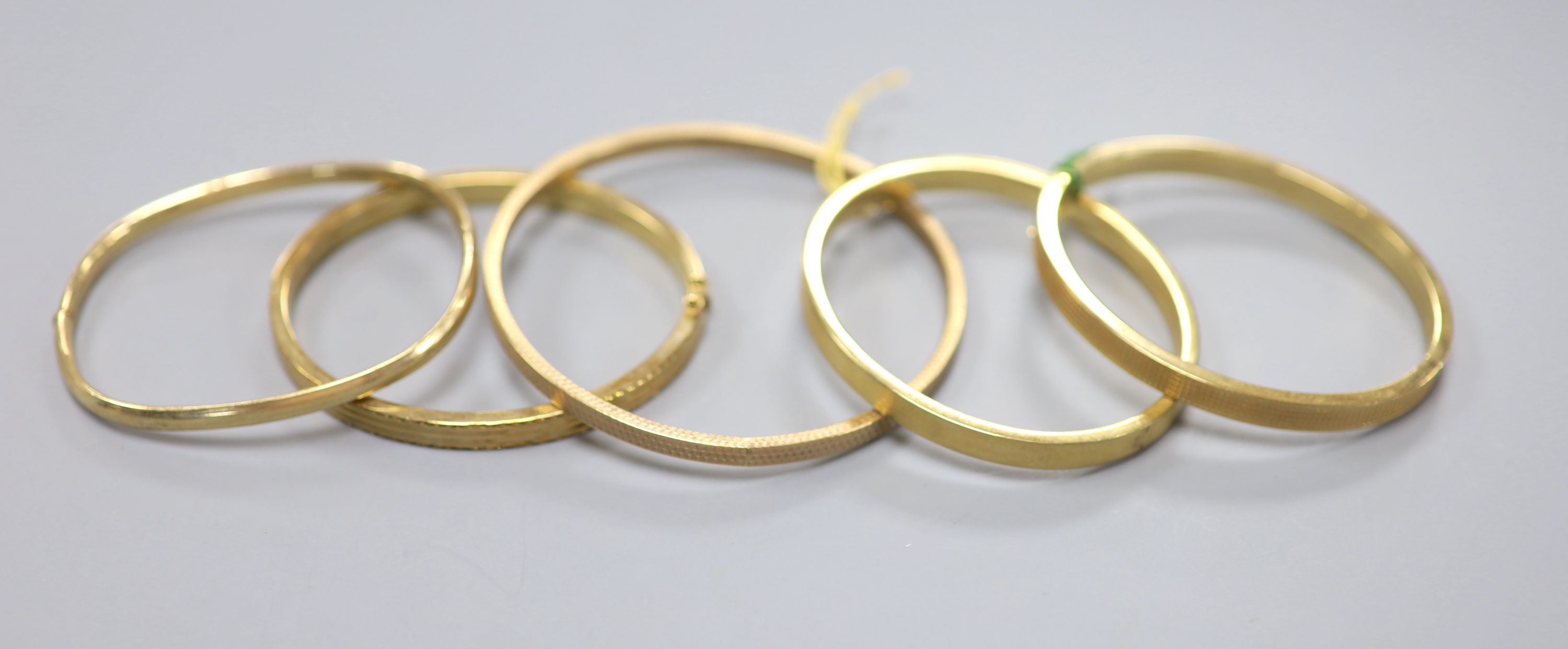 Two modern 9ct gold bangles, one hinged, 33.5 grams and three 9ct gold filled hinged bangles.